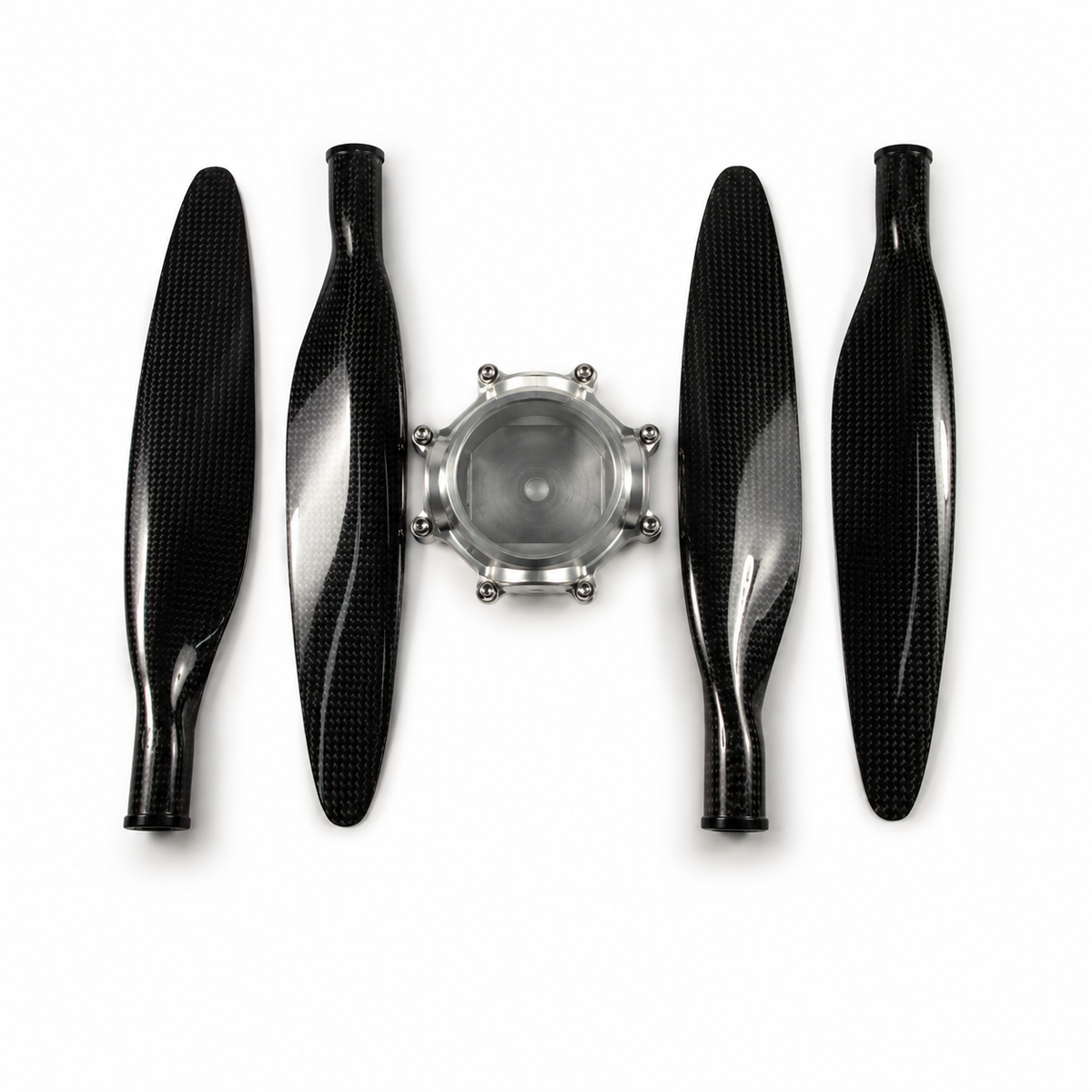 Four black carbon fiber propeller blades arranged symmetrically around a silver metal central hub on a white background.