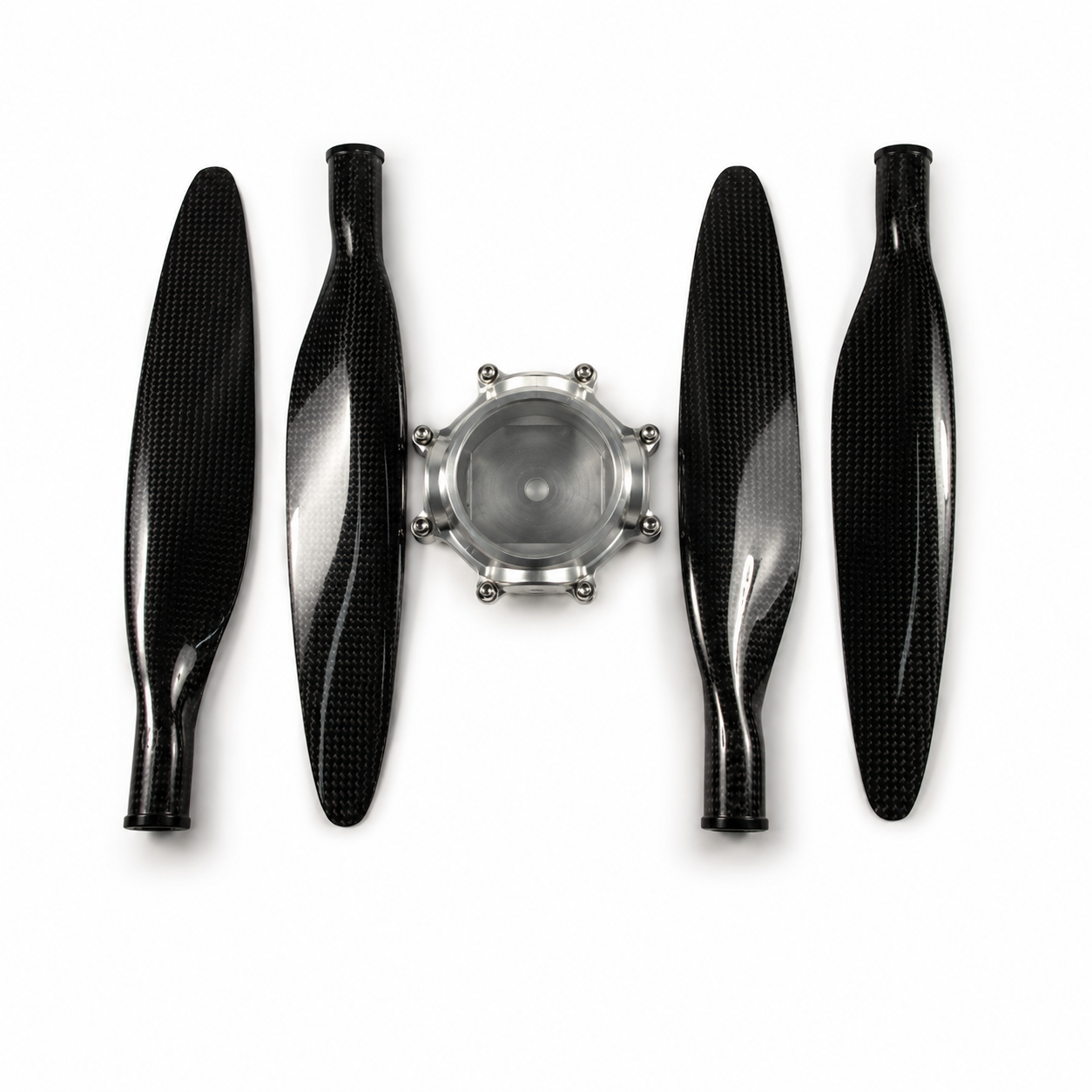 Four black carbon fiber propeller blades arranged symmetrically around a silver metal central hub on a white background.