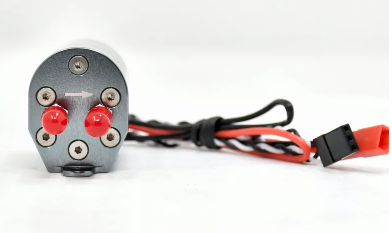 Mechanical component with red knobs and wiring on a white background