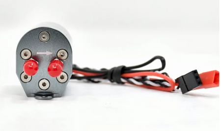 Mechanical component with red knobs and wiring on a white background