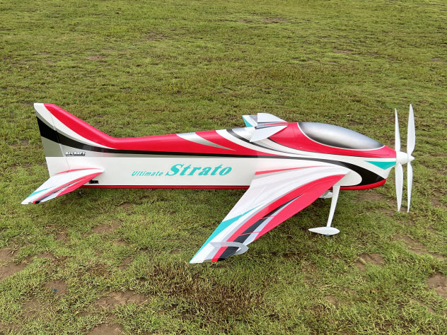 Model airplane with 'Ultimate Strato' branding on a grassy field