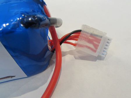 Blue motor with red and black wires connected to a white connector on a light gray background